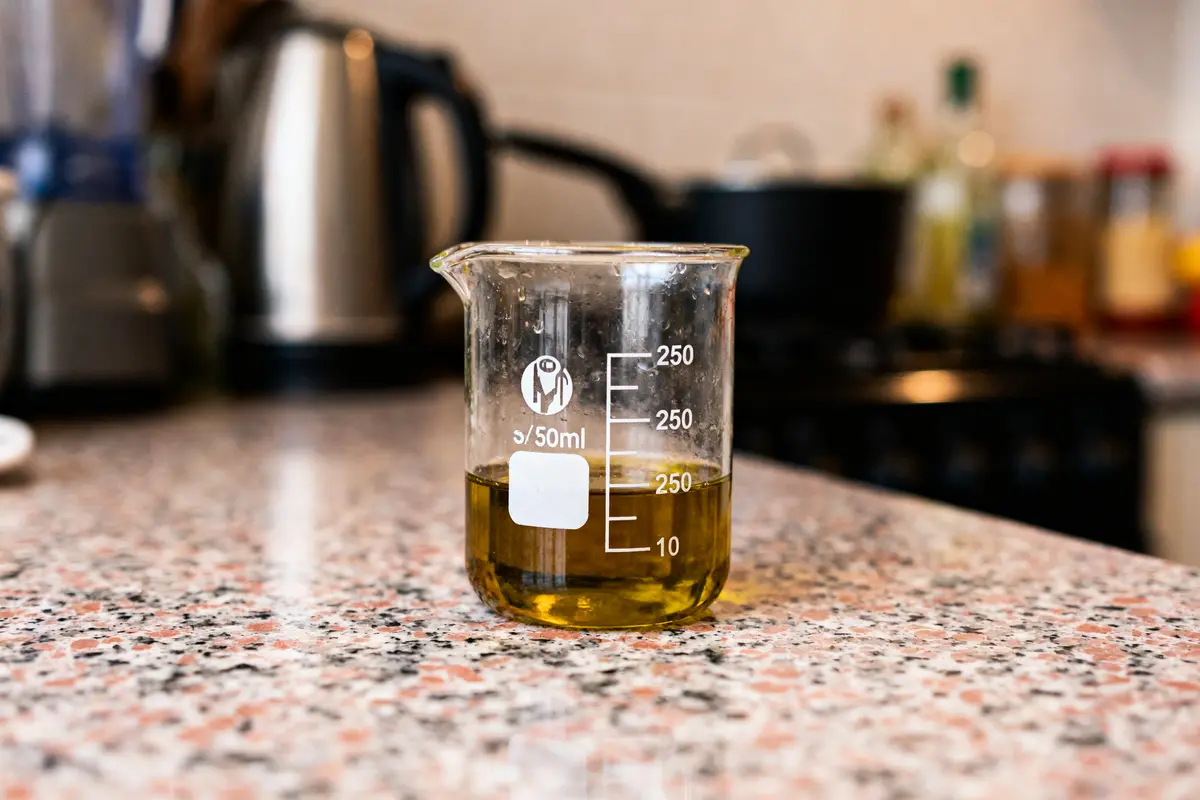 Bécher contenant liquide jaune mesuré à 25 centilitre sur un comptoir de cuisine