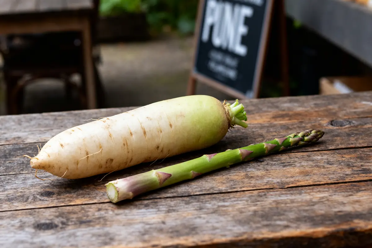 Un radis blanc et une asperge sur une table en bois légume en D