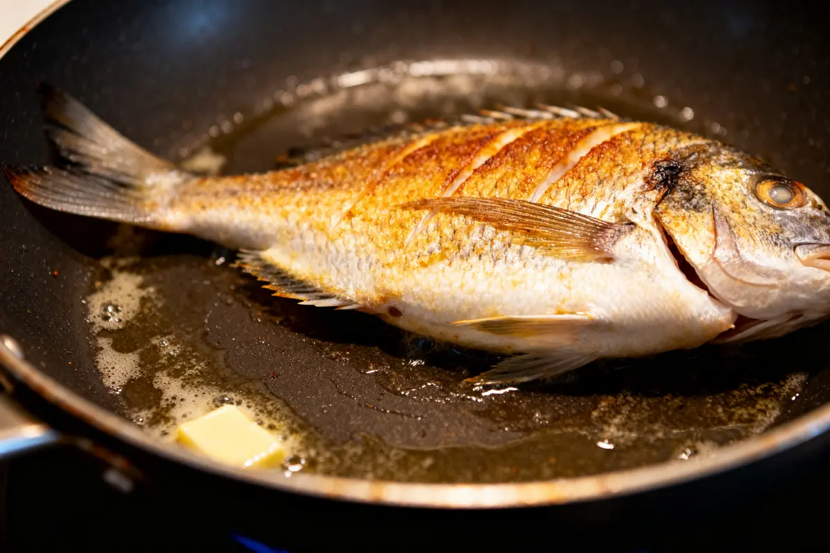 Poisson doré dans une poêle avec beurre montrant la cuisson de la sole à la poêle