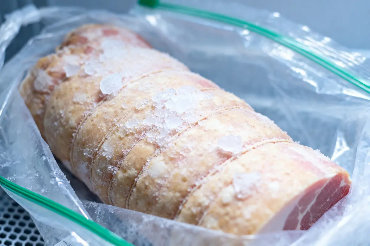 Bloc de jambon blanc congelé emballé dans un sac plastique transparent au congélateur