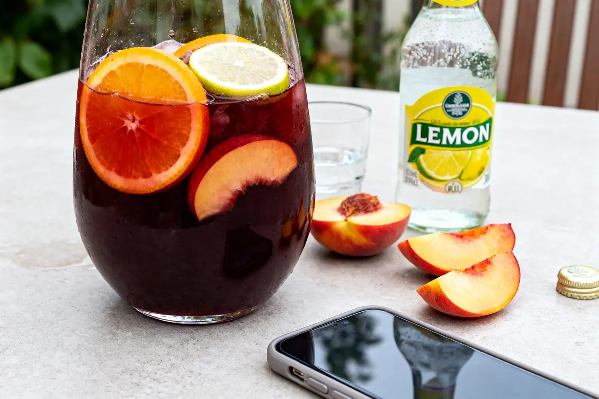 Carafe de sangria avec agrumes, nectarines et limonade montrant que rajouter dans une sangria toute faite