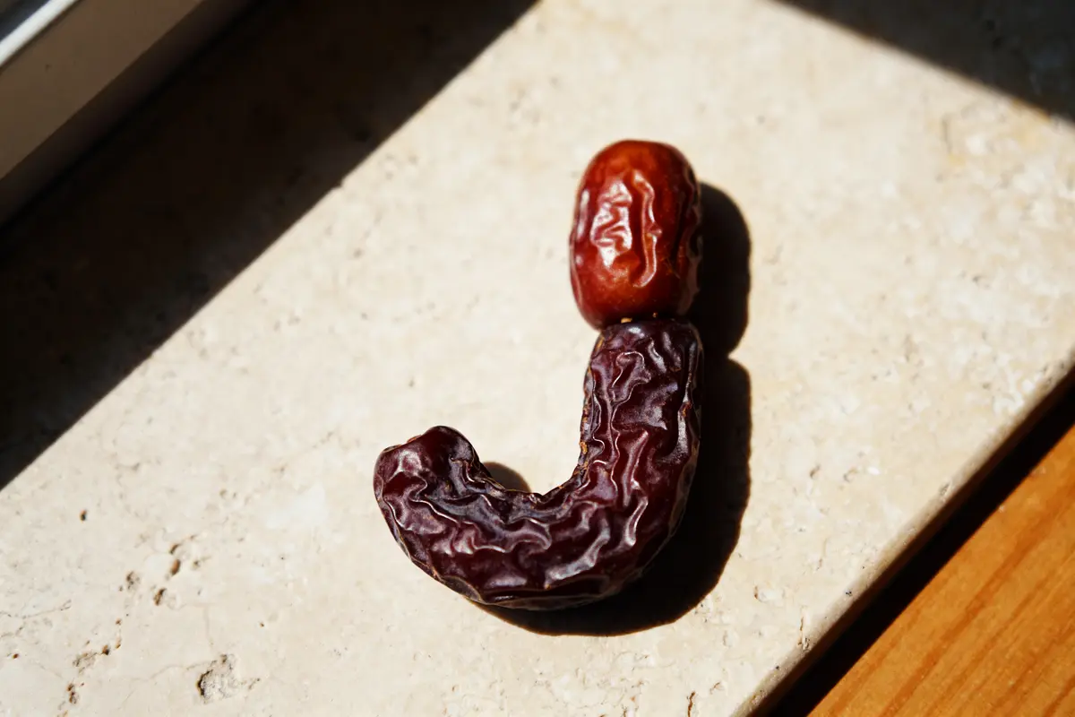 Deux dattes formant la lettre J, représentant un fruit ou légume en J