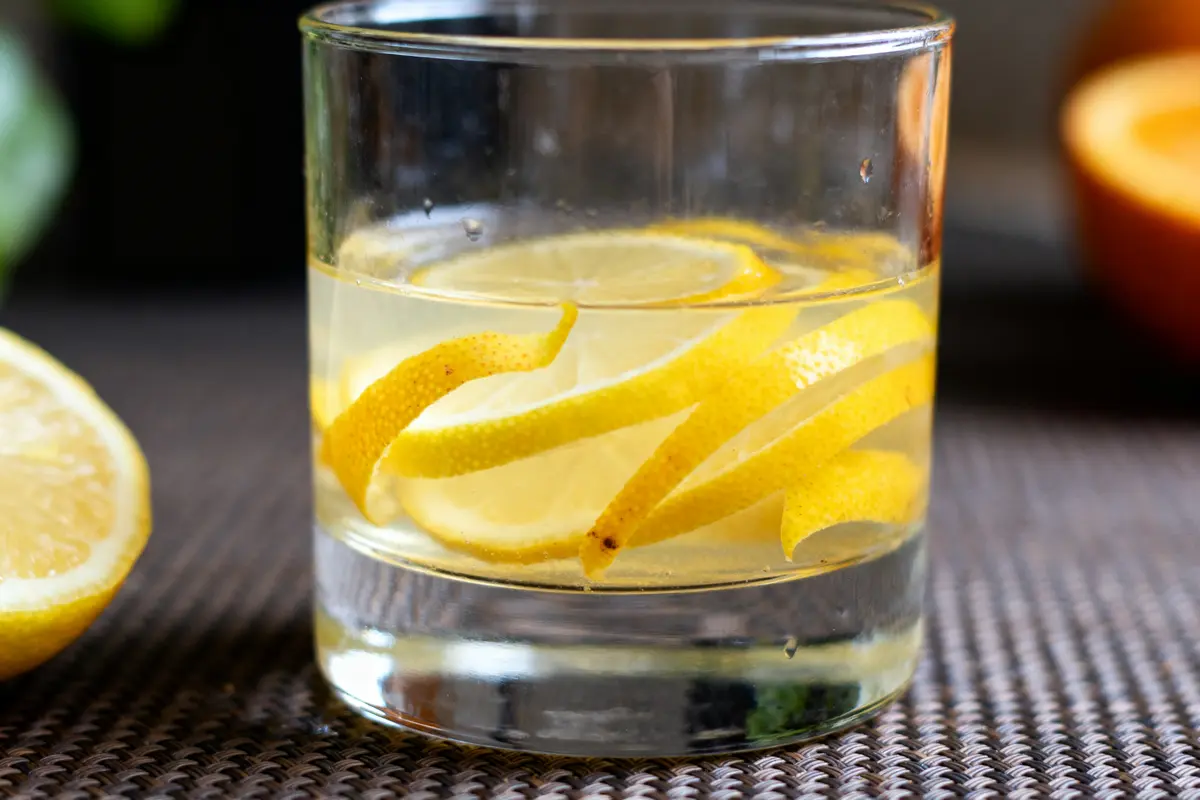 Verre de limoncello avec zestes de citron soulignant le gout du limoncello frais et vibrant